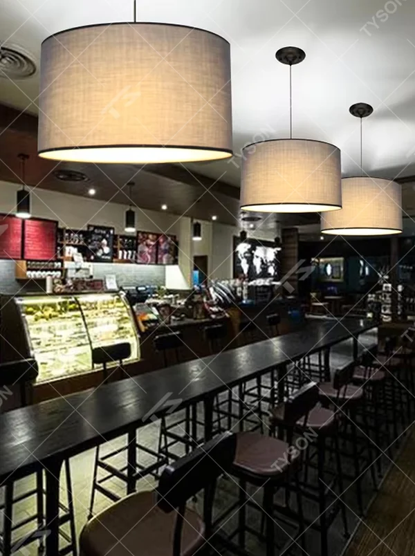 Minimalist beige fabric cylindrical hanging chandelier, metal suspension rod + fabric lampshade, soft and uniform lighting, creating a warm and leisure atmosphere.