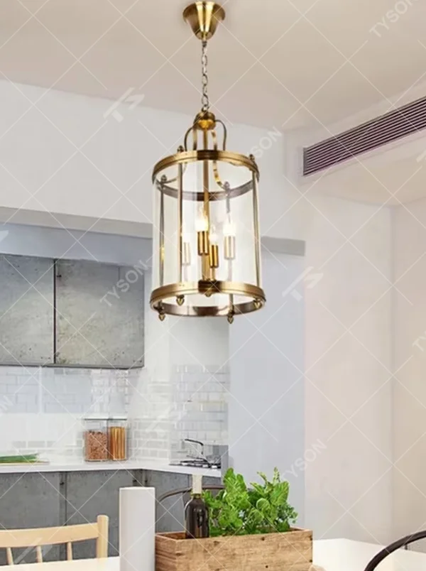 Light luxury golden metal cage-style cylindrical glass cover candelabra chandelier, golden frame + transparent cylindrical glass cover + candle-shaped bulbs, soft warm light, suitable for modern minimalist dining area atmosphere.