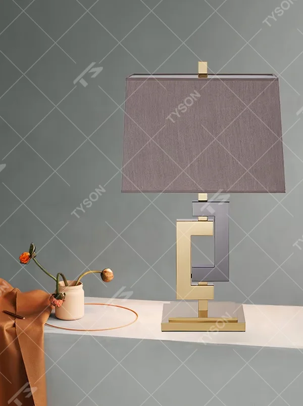 Light luxury gold-gray color-blocking geometric square frame table lamp, gold + dark gray metal geometric stand + dark gray fabric rectangular lampshade, soft and high-end lighting, creating a light luxury modern atmosphere.
