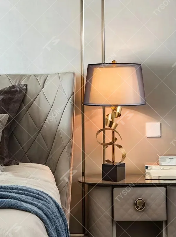 Light luxury golden spiral-shaped table lamp, golden spiral stand + black square base + gradient gray fabric lampshade, soft warm light, creating an elegant light luxury bedroom atmosphere.