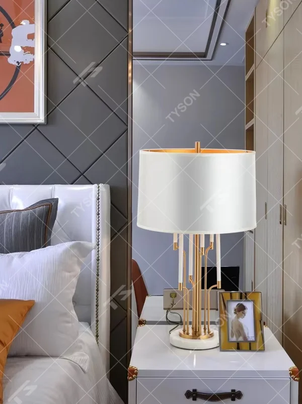 Light luxury golden multi-rod shaped table lamp, white fabric gold-edged lampshade + golden multi-rod stand + white-gold base, soft warm light, creating a high-end light luxury bedroom atmosphere.