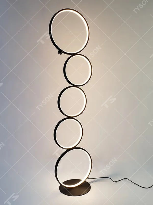 Modern art-style multi-layer luminous ring floor lamp, black frame + warm light ring light source + stacked shape, creating a simple artistic space atmosphere.