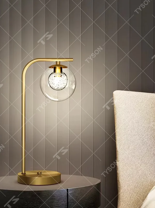 Modern light luxury golden curved pole transparent glass ball shade glitter bulb table lamp, warm light effect, creating a minimalist exquisite atmosphere.