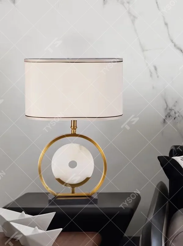 Modern light luxury gold ring white spherical base beige trimmed fabric shade table lamp, warm light effect, creating an elegant home atmosphere.