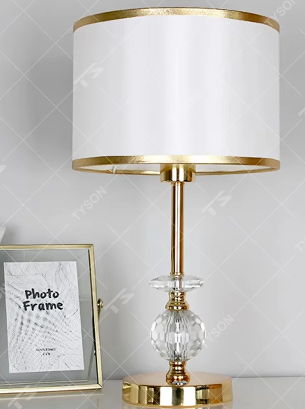 Modern light luxury gold-trimmed white shade golden pole cut crystal decorative table lamp, warm light effect, creating an exquisite and elegant atmosphere.