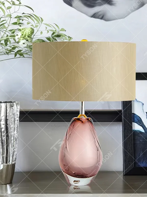 Modern art pink waterdrop glass base beige fabric shade table lamp, warm light effect, creating an elegant artistic atmosphere.