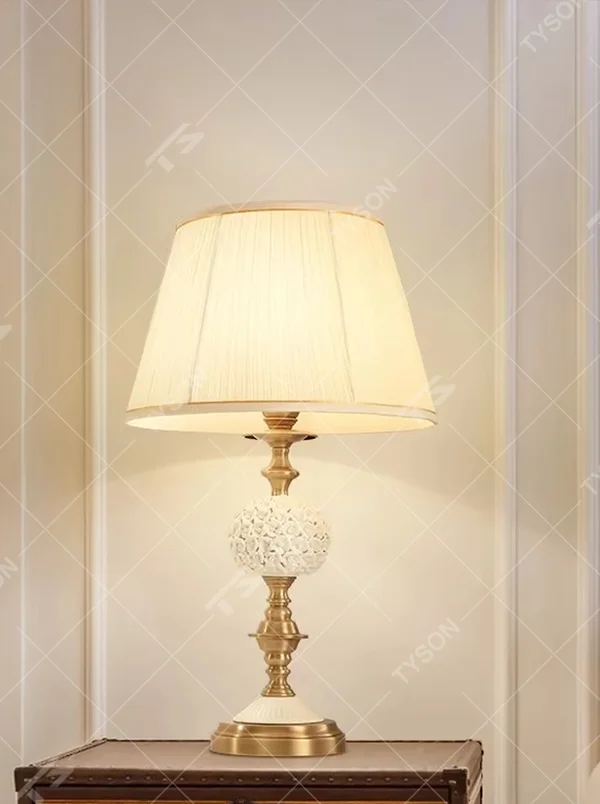 Vintage carved glass table lamp (brass stand + pleated fabric shade), warm light effect, creating an elegant vintage light luxury home atmosphere.