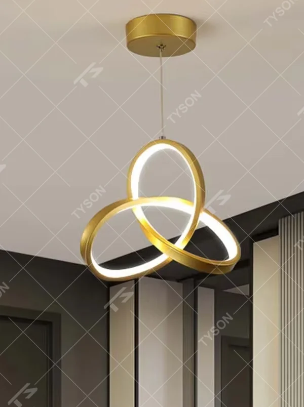 Modern minimalist black-gold interwoven triple-ring LED pendant light, warm light effect, creating a minimalist artistic space atmosphere.