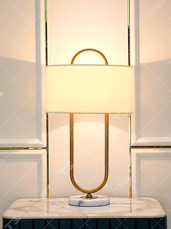 Light luxury U-shaped gold frame table lamp (gold ring stand + fabric shade + marble base), warm light effect, creating an elegant and high-end home atmosphere.