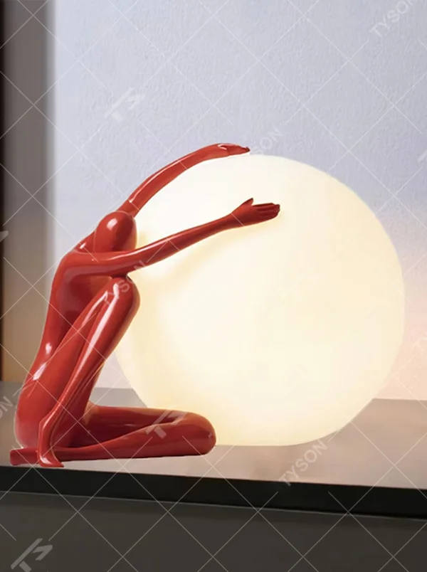 Artistic red sculpture humanoid lifting spherical soft light table lamp, warm light effect, creating a personalized artistic space atmosphere.