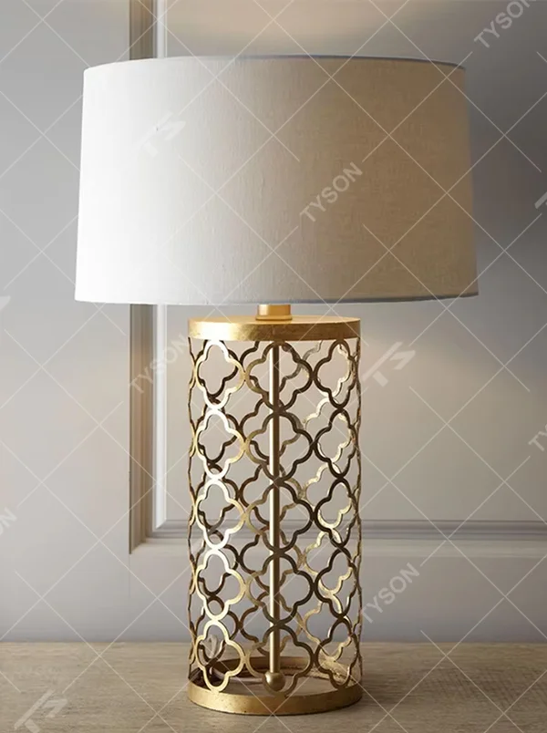 Light luxury golden hollow pattern table lamp (white fabric shade), warm light effect, creating an exquisite retro space atmosphere.