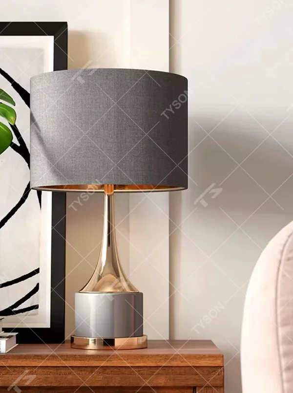 Light luxury gray-gold fabric lampshade metal base table lamp (gray fabric shade + gold pole + gray stone-pattern base), warm light effect, creating an exquisite and elegant atmosphere.