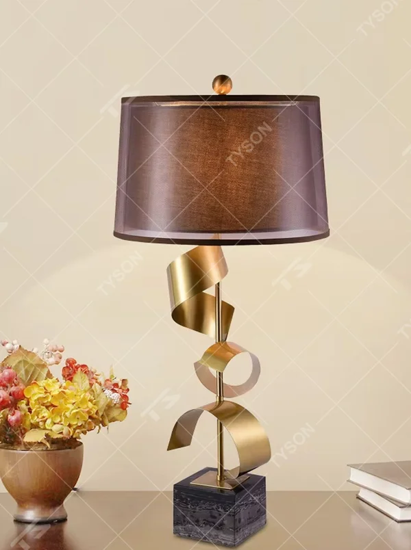 Light luxury spiral metal table lamp (gold spiral pole + pink-brown fabric shade), warm light effect, creating a dynamic and high-end warm space atmosphere.