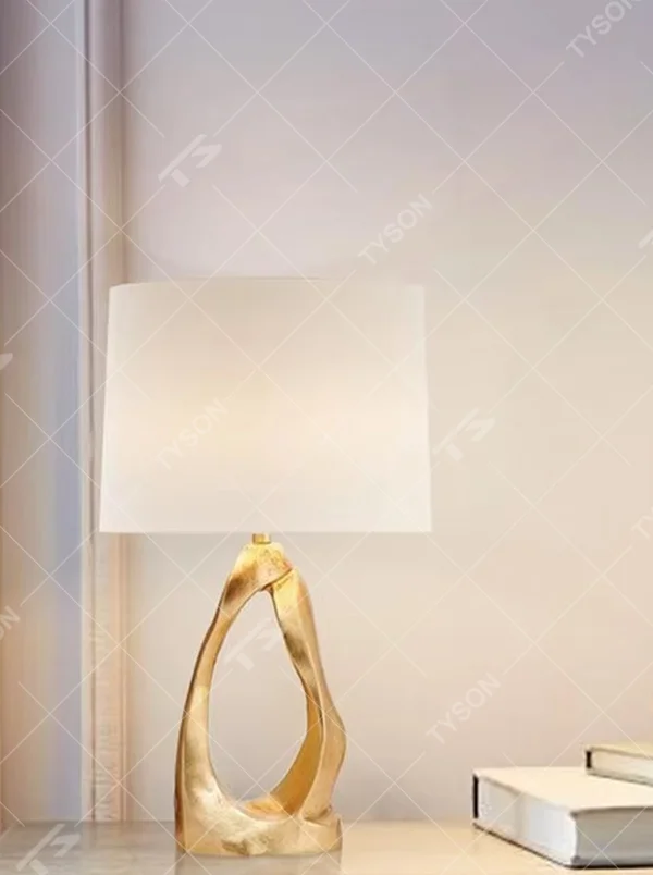 Art texture gold base table lamp (irregular gold base + fabric shade), warm light effect, creating an artistic and high-end light luxury home atmosphere.