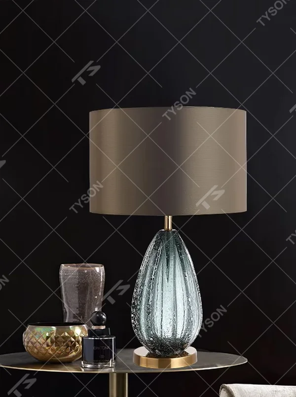 Light luxury textured glass table lamp (dark green glass + metal base), warm light effect, creating an elegant and high-end home space atmosphere.