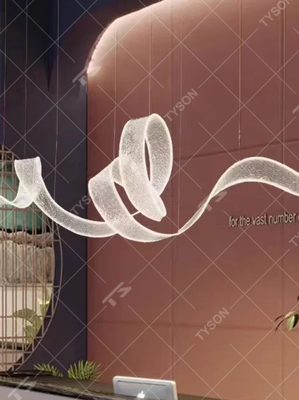 Art ribbon curve chandelier (transparent texture acrylic + flowing shape), warm light effect, creating a minimalist artistic space atmosphere.