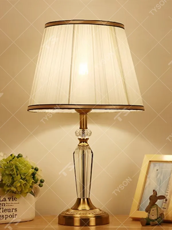 Light luxury crystal fabric table lamp (pleated fabric lampshade + crystal lamp post + antique bronze metal base), warm light effect, creating an elegant and luxurious home atmosphere.