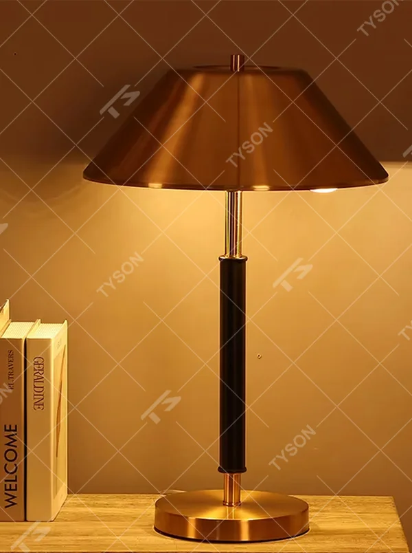 Light luxury gold-brown leather table lamp (gold metal lampshade + dark brown leather lamp post + metal base), warm light effect, creating a retro and high-end office and home atmosphere.