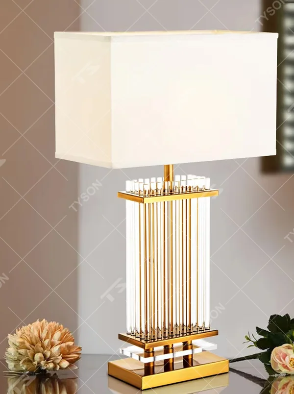Light luxury gold column crystal table lamp (gold metal vertical strips + crystal lamp post + square fabric lampshade), warm light effect, creating an exquisite and high-end home atmosphere.