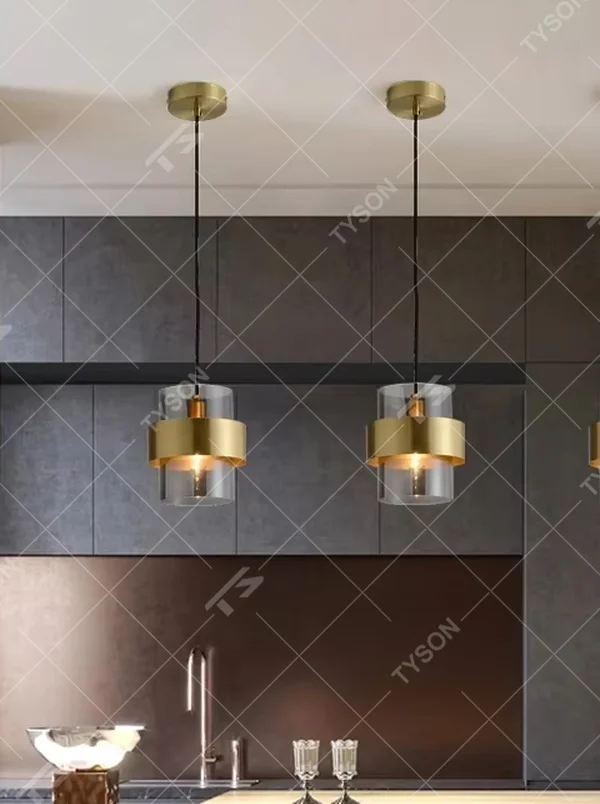 Light luxury gold ring glass triple chandelier (transparent glass lampshade + gold metal ring + black hanging wire with gold base), warm light effect, creating a modern and high-end kitchen and dining space atmosphere.