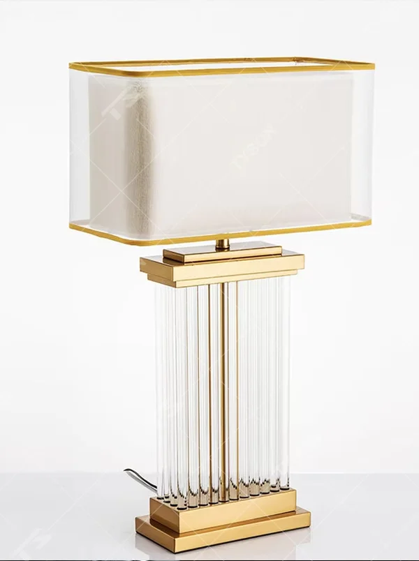This light luxury modern table lamp features a gold metal frame, paired with a transparent crystal column lamp body and a double-layer square lampshade (inner fabric for soft light, outer transparent acrylic with gold trim). It serves both lighting and decorative purposes, ideal for bedroom bedside, living room side tables, hotel guest rooms and light luxury commercial spaces.