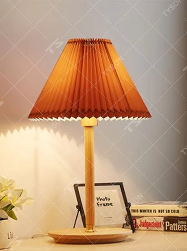Nordic-style wooden pleated table lamp, with a light wood lamp pole and base paired with an orange pleated fabric lampshade, providing soft and warm light, designed to enhance the cozy atmosphere of spaces, suitable for bedroom nightstands, living room side tables, homestay guest rooms, etc.
