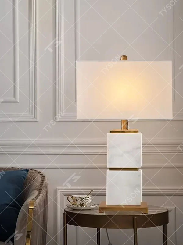 Light luxury stacked marble table lamp, natural marble base with gold metal connections, rectangular fabric lampshade for soft and eye-protective lighting, designed to enhance space texture, suitable for bedroom nightstands, living room side tables, hotel guest rooms, etc.