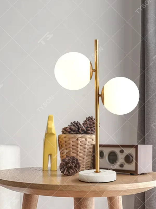 This modern light luxury double-ball table lamp features a gold metal stand, paired with milky white glass ball lampshades and a white marble base, with a simple and elegant staggered double-ball layout, serving both lighting and decorative purposes, ideal for living room side tables, bedroom bedside tables, light luxury homestays and other spaces.