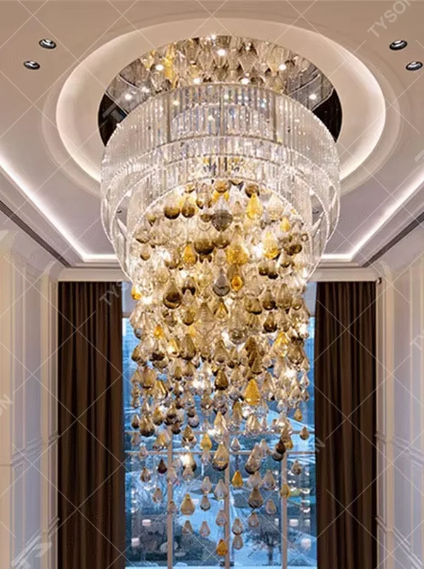 This large dome crystal chandelier features a multi-layered hanging teardrop design made of transparent and yellow-white gradient crystals, serving both lighting and artistic decoration purposes, with free design and professional engineering customization available, ideal for high-end high-ceiling spaces such as villa staircases, hotel lobbies, and sales offices.