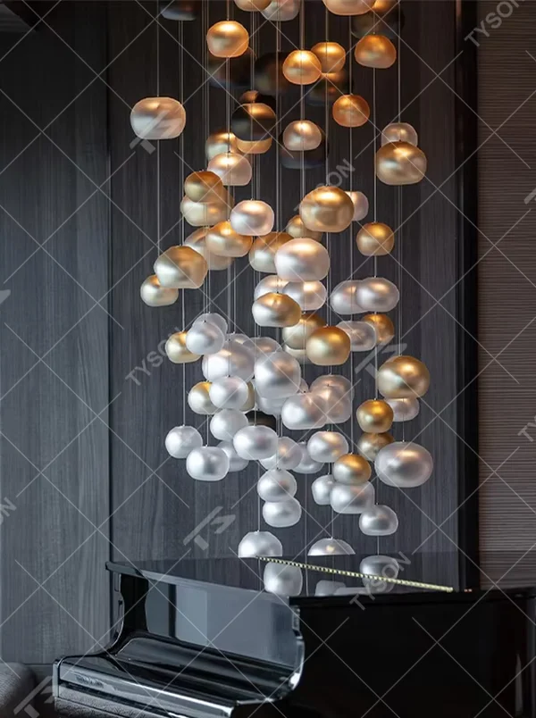 This artistic pendant chandelier consists of spherical lamp shades with a gradient from gold to silver, resembling flowing pearls or bubbles. It serves both lighting and decorative purposes, ideal for high-ceiling spaces, villa living rooms, art galleries, and high-end clubs.