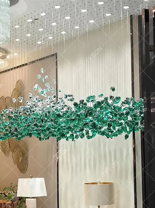 This large custom art crystal chandelier features a suspended green plant/wave shape made of green-white gradient crystal clusters, hung with slender suspension rods, serving both lighting and artistic decoration purposes, ideal for high-ceiling commercial spaces such as sales offices, hotel lobbies, and high-end clubs.