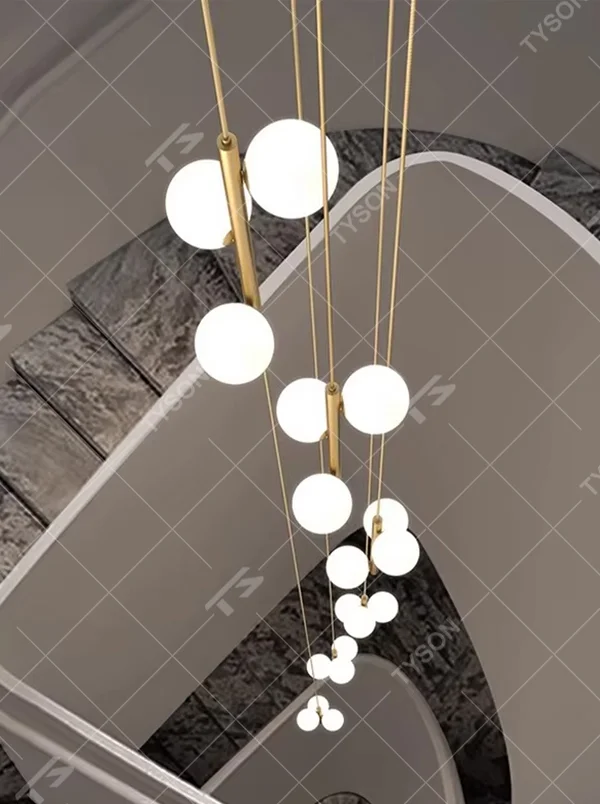 Nordic light luxury style staggered spherical chandelier, with gold metal suspension rods paired with milky white luminous bulbs, arranged in a cascading staggered layout. It emits soft and warm light, combining decorativeness and lighting function, suitable for core lighting and atmosphere creation in high-ceiling spaces such as duplex stairs, high-ceiling living rooms, and villa hollow areas.
