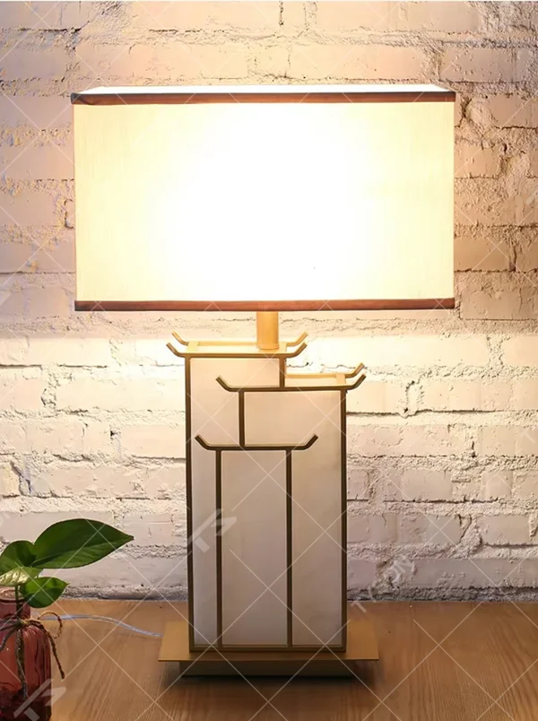 This is a new Chinese style table lamp, featuring a rectangular fabric lampshade paired with a geometric splicing base with Chinese architectural elements, which has both lighting and decorative functions, suitable for bedrooms, studies, tea rooms, new Chinese-style homes and hotel guest rooms and other spaces.