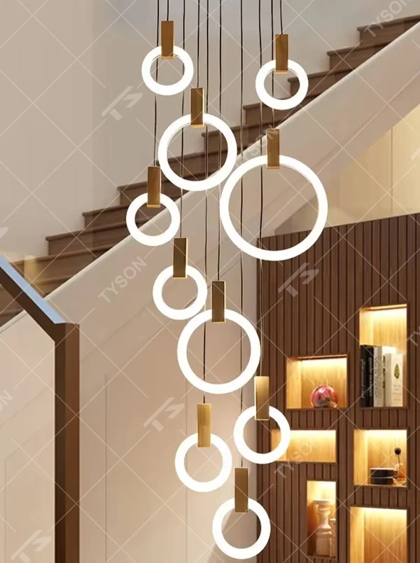 Modern light luxury multi-layer ring LED chandelier, composed of luminous rings of varying sizes and gold metal top bases, hanging in a staggered manner to present a flowing rhythmic sense. It emits soft and even light, combining decorativeness and lighting function, suitable for main lighting and atmosphere creation in high-ceiling spaces such as duplex stairs, high-ceiling living rooms, and villas.