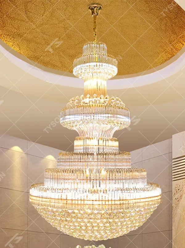 This is a luxurious pagoda-style multi-layered round crystal chandelier, featuring a gold metal frame paired with dense crystal strips in a tiered circular structure. It emits brilliant and gorgeous light, serving both lighting and decorative purposes, suitable for large luxurious spaces such as hotel lobbies, villa high-ceiling living rooms, banquet halls, and high-end clubs.