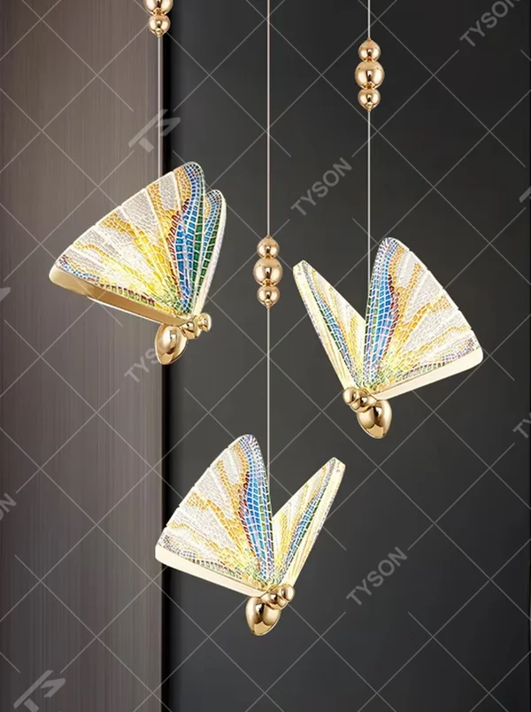 Light luxury butterfly-wing shaped chandelier, featuring butterfly wing textures made of colored mosaic glass, paired with a gold metal base and hanging structure. It emits soft, transparent, and colorful light, combining artistic decorativeness and lighting function, suitable for atmosphere creation and supplementary lighting in spaces such as entrances, stairwells, and bedroom nightstands.