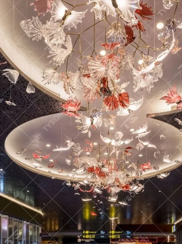 This is a customized artistic flower ceiling chandelier, composed of flower and branch-shaped components made of transparent and red-pink glass/acrylic material, paired with a circular luminous ceiling plate, which has both lighting and artistic decoration functions, suitable for large commercial spaces such as hotel lobbies, banquet halls, and high-end clubs.