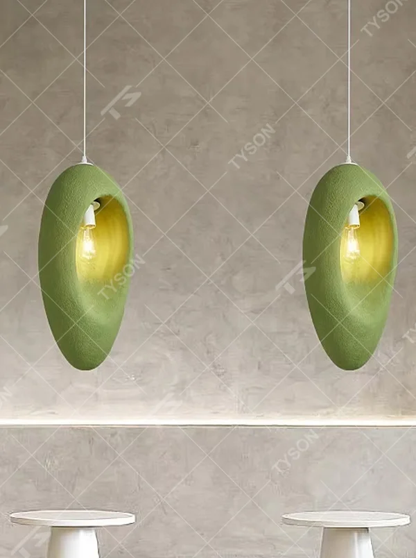 This is a modern wabi-sabi style pebble-shaped pendant lamp, made of frosted cement/resin material with a semi-embedded lighting design, available in colors like gray and green, which has both lighting and decorative functions, suitable for modern minimalist, wabi-sabi style bedrooms, entrances, cafes and other spaces.