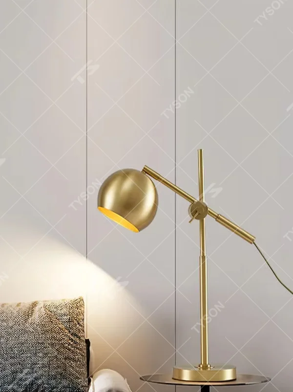 This is a modern light luxury style gold metal table lamp, featuring a spherical lampshade paired with an adjustable long arm and a stable base, which has both lighting and decorative functions, suitable for bedroom nightstands, study desks, hotel guest rooms and other spaces.