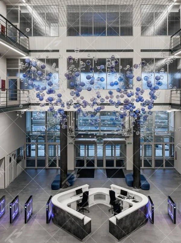 This is a modern art-style suspended bubble installation lamp, composed of transparent and blue-purple gradient spherical elements hung in a staggered manner, with both decorative and lighting functions, ideal for multi-story high-ceiling public spaces such as shopping mall atriums and office building lobbies.