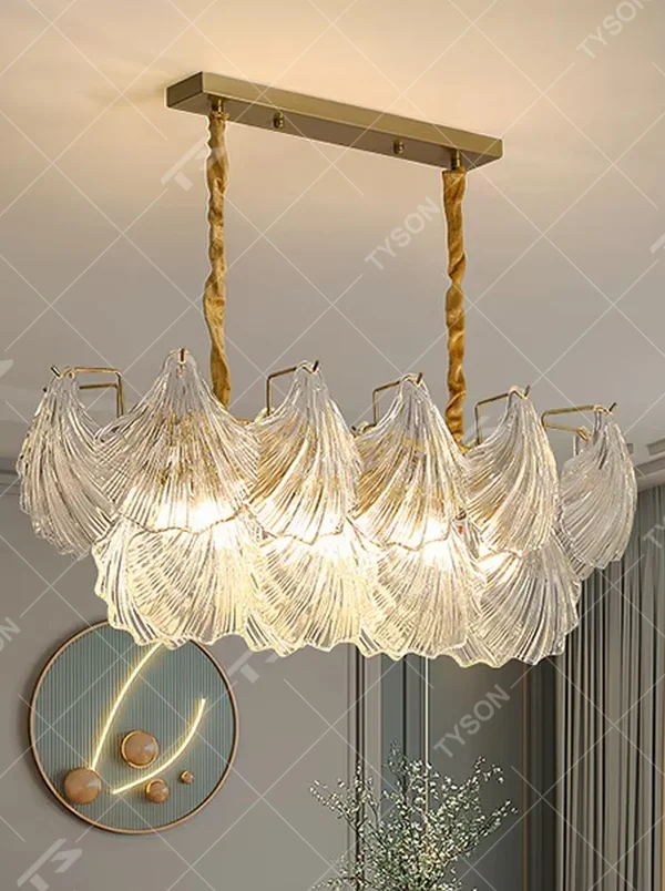 A modern light luxury style art chandelier, featuring a gold metal frame paired with multi-layered fan-shaped textured transparent glass panels, shaped like overlapping ginkgo leaves in bloom. It emits a soft and brilliant glow when lit, combining decorative appeal with practical illumination, ideal for creating a romantic and elegant space atmosphere.
