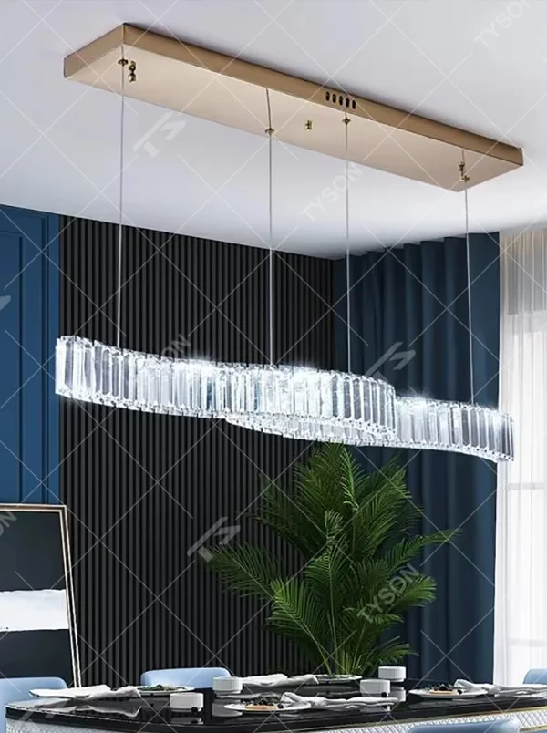 This modern light luxury linear chandelier features a gold metal ceiling plate, paired with faceted crystal strips to create an irregular undulating shape. Light refracts through the crystals to emit a brilliant glow, serving both lighting and decorative purposes, suitable for modern light luxury spaces such as dining rooms and bars.