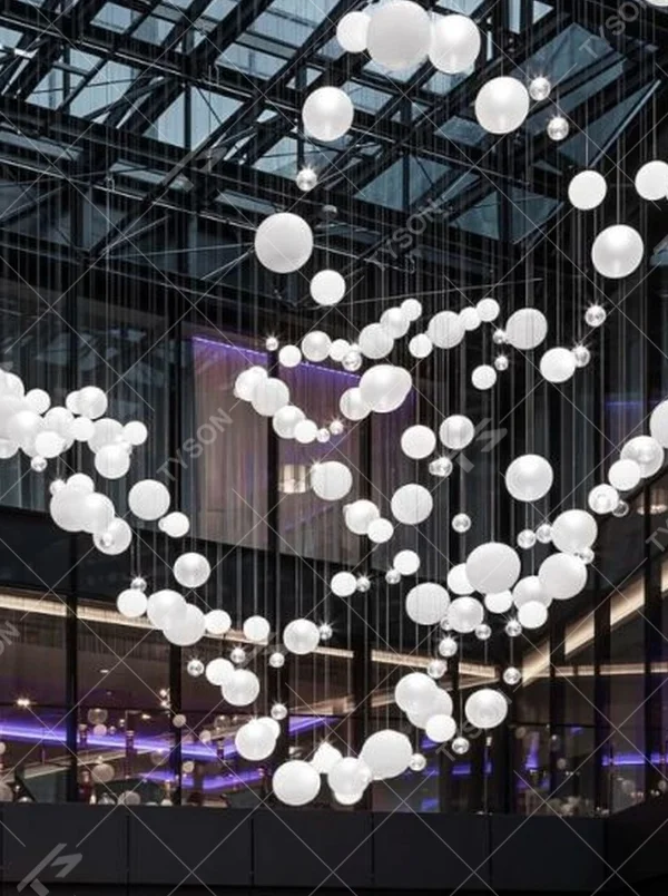 This is a modern art-style suspended spherical light array, composed of densely hung white spherical LED lights of varying sizes, presenting a flowing cloud cluster effect, with both decorative and lighting functions, ideal for public commercial spaces such as shopping mall atriums and high-ceiling office buildings.