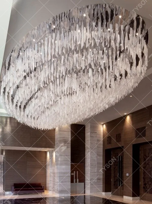 This large oval artistic chandelier is composed of a large number of transparent glass/acrylic pieces hung in a staggered manner, presenting a fluffy and soft visual effect like a cloud. The light refracts through the material to emit a brilliant and transparent glow, serving both lighting and decorative purposes, suitable for core decoration and lighting in large spaces such as hotel lobbies and high-end clubs.