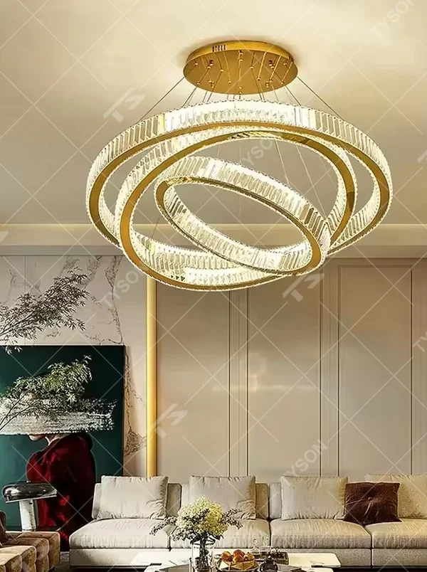 This modern light luxury multi-layer interlaced ring crystal chandelier features a gold metal frame paired with a high-transparency crystal lamp body. The multi-layer rings are staggered and interwoven to present a dynamic interstellar shape. The light refracts through the crystal to emit a brilliant and soft glow, serving both lighting and decorative purposes, suitable for modern light luxury style spaces such as living rooms and dining rooms.