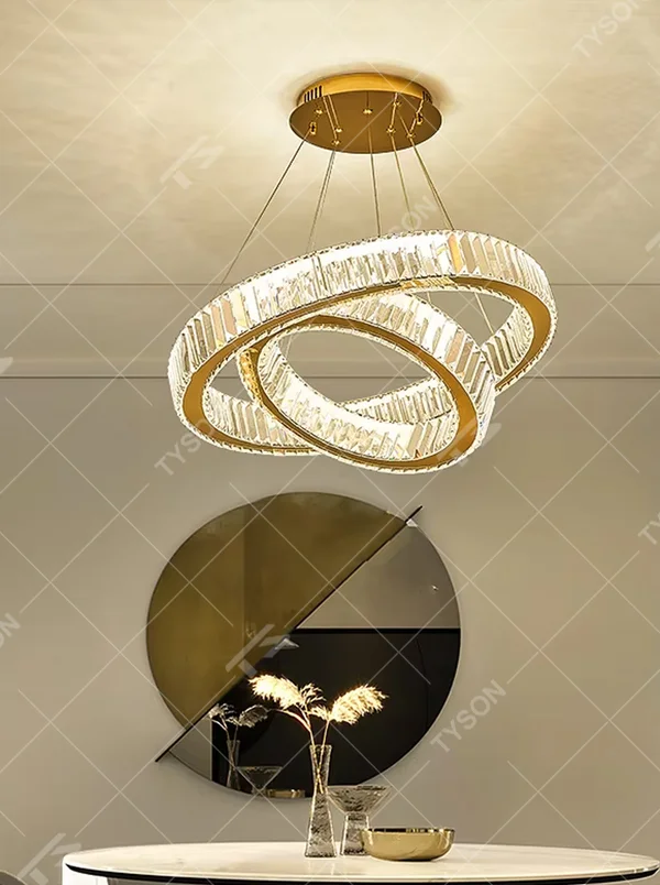 A modern light luxury three-tier interlocking ring crystal chandelier, featuring a gold metal frame inlaid with high-transparency crystal strips. Its interlocking ring structure resembles cosmic orbits, emitting a brilliant yet soft glow when lit, combining decorative appeal with practical illumination, ideal for creating a high-end and sophisticated space atmosphere.