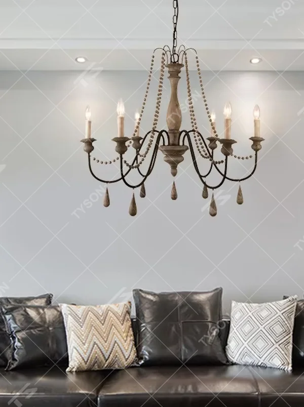 A French country retro style 6-head chandelier, featuring a weathered solid wood main frame paired with iron lamp arms, wooden bead chains and teardrop pendants, using candle-shaped bulbs. It emits a warm and soft glow when lit, combining decorative appeal with practical illumination, ideal for creating a cozy and retro space atmosphere.