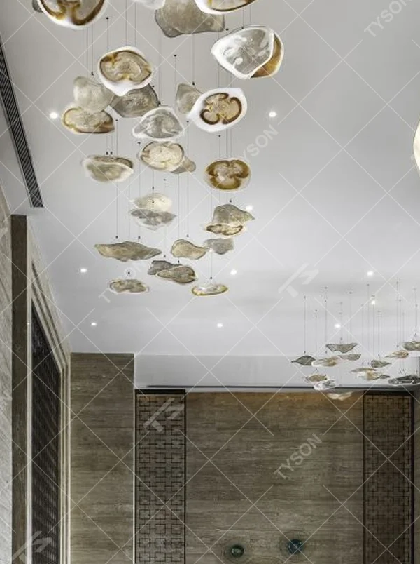 This modern art cloud-slice chandelier consists of irregular transparent and gold cloud-shaped ornaments hung staggered, as light as floating clouds. Light passes through the ornaments to emit a soft and transparent halo, serving both lighting and decorative purposes, suitable for high-end commercial spaces such as luxury sales offices and clubs.