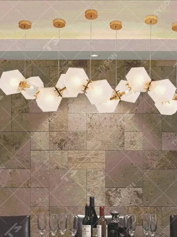 A modern light luxury style wave-shaped linear chandelier, suspended by gold wires, paired with frosted geometric polyhedral lampshades. It emits a soft and warm glow when lit, combining decorative appeal with practical illumination, ideal for creating an exquisite and high-end space atmosphere.