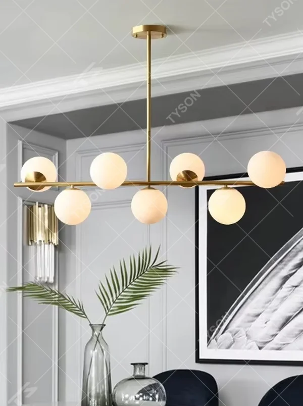 A modern light luxury style linear molecular ball chandelier, featuring a gold metal frame paired with asymmetrically arranged milky white glass glowing spheres. It emits a soft and uniform glow when lit, combining decorative appeal with practical illumination, ideal for creating a minimalist and sophisticated space atmosphere.